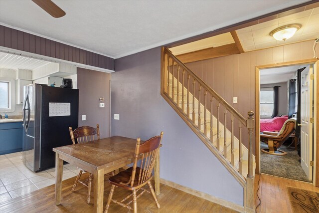 dining space with light wood finished floors, ceiling fan, and stairway