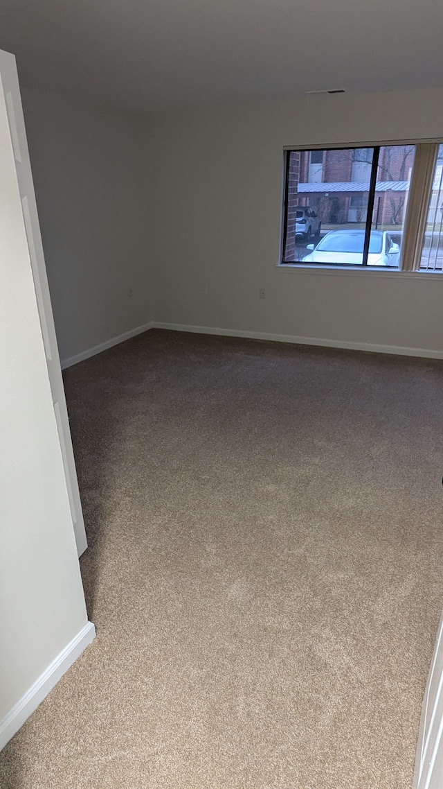 unfurnished room with carpet and baseboards