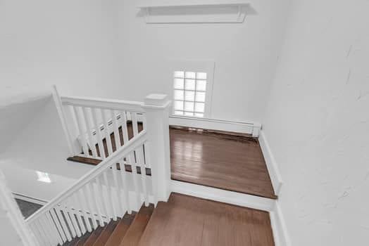 stairway featuring baseboards, wood finished floors, and a wall mounted air conditioner