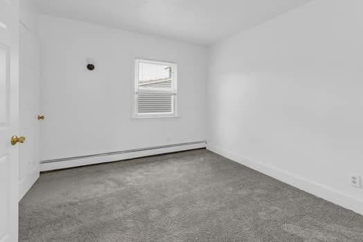 unfurnished room with a baseboard radiator