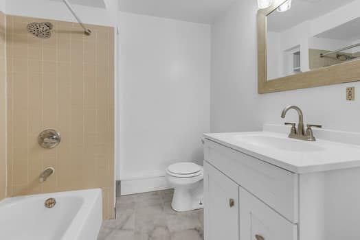 bathroom featuring shower / tub combination, vanity, and toilet