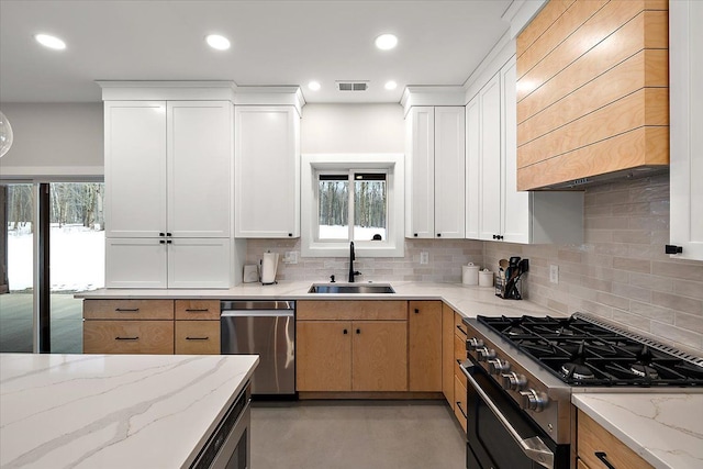 kitchen featuring decorative backsplash, stainless steel appliances, a sink, and recessed lighting