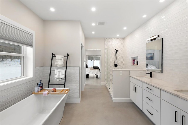 full bath featuring a freestanding tub, ensuite bath, a sink, and recessed lighting