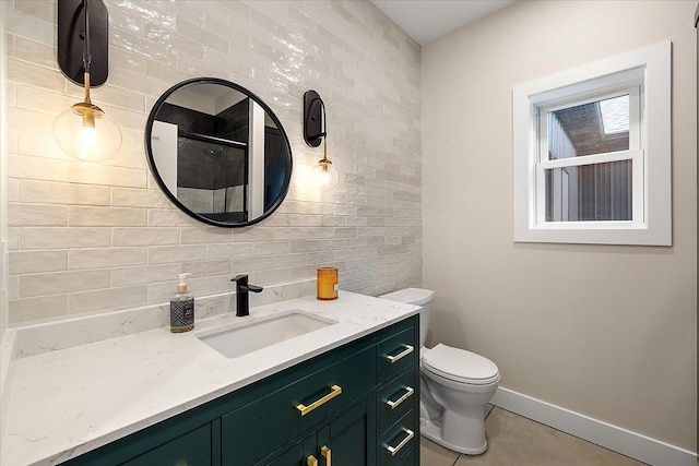 bathroom with toilet, vanity, baseboards, tile patterned floors, and walk in shower