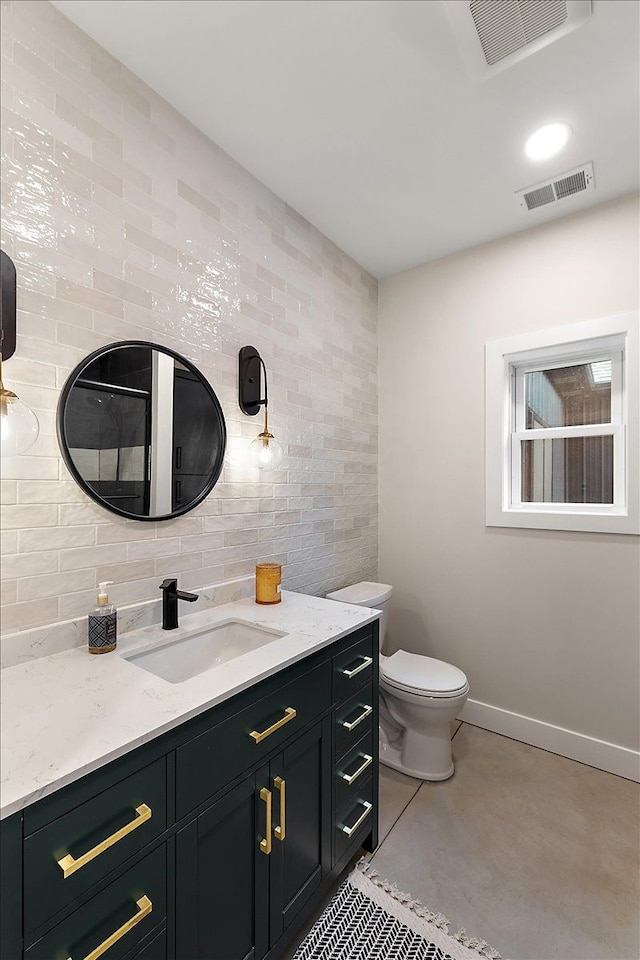 bathroom with baseboards, concrete floors, visible vents, and vanity