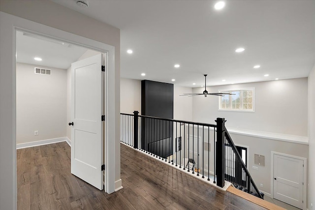 hallway featuring baseboards, visible vents, wood finished floors, an upstairs landing, and recessed lighting