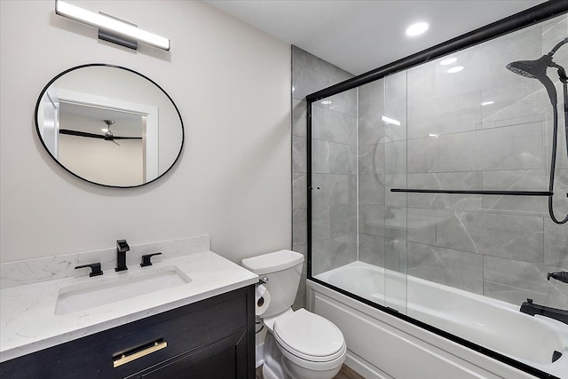 bathroom with toilet, enclosed tub / shower combo, and vanity