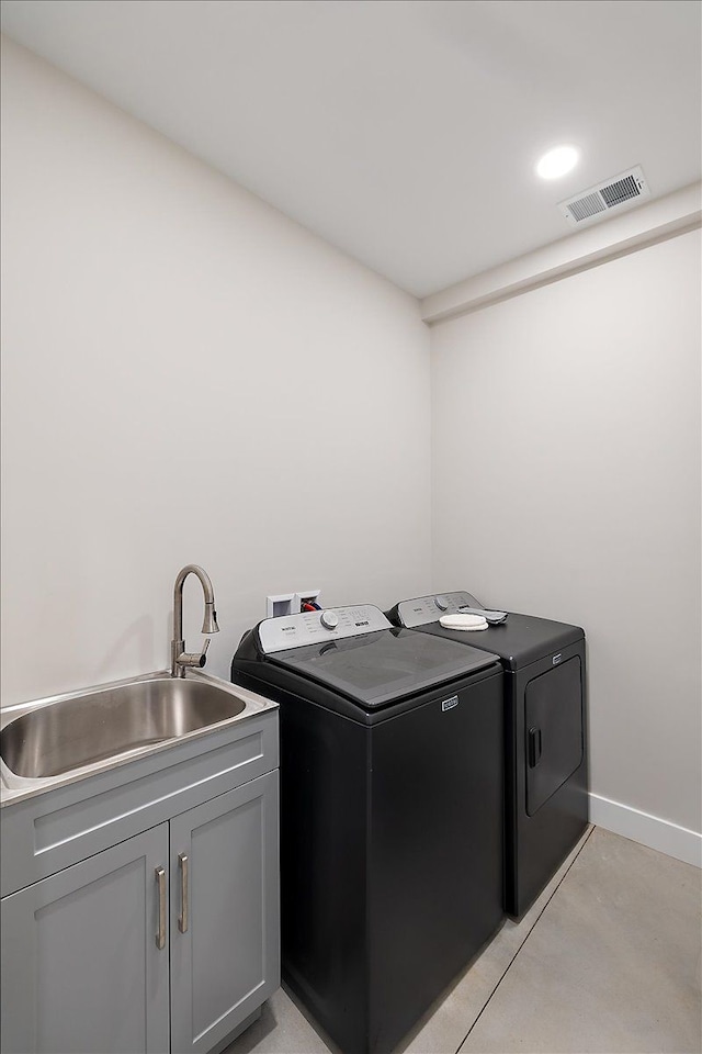 laundry room featuring cabinet space, baseboards, visible vents, independent washer and dryer, and a sink