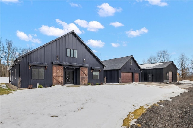 modern farmhouse style home with an outbuilding, metal roof, a standing seam roof, and a detached garage