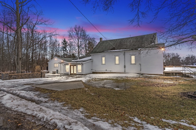 snow covered house featuring concrete driveway