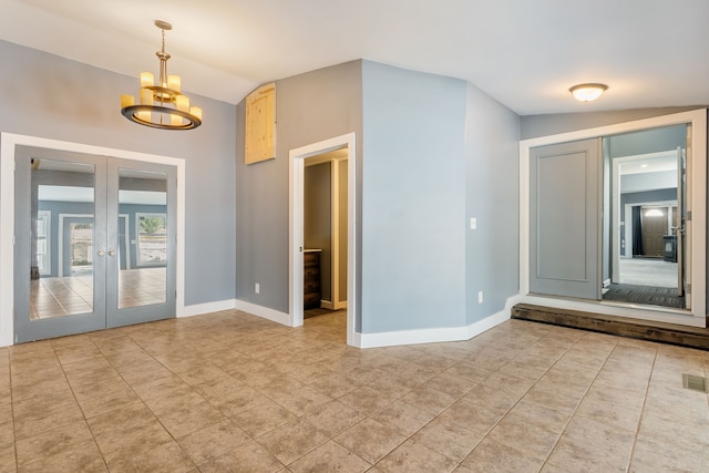 empty room with vaulted ceiling, french doors, and baseboards