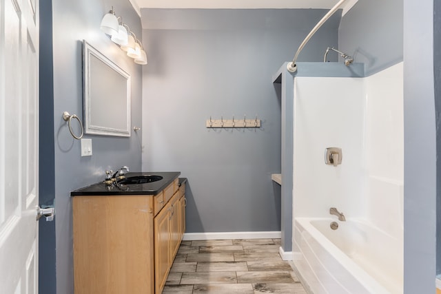 full bath featuring shower / bathtub combination, baseboards, wood finish floors, and vanity