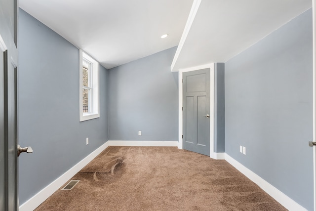 carpeted empty room featuring visible vents and baseboards