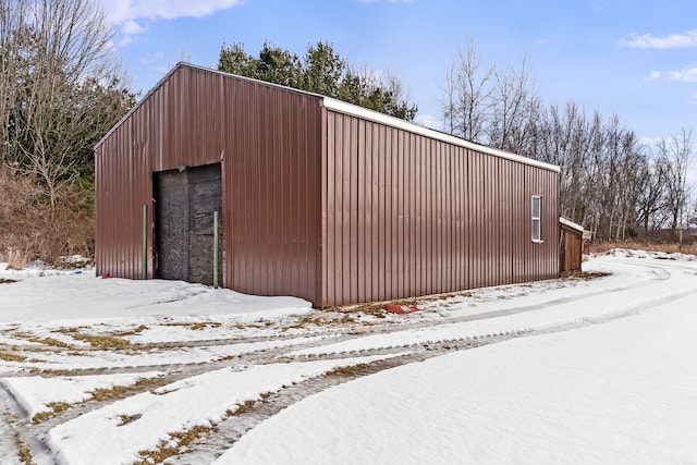 snow covered structure featuring an outbuilding