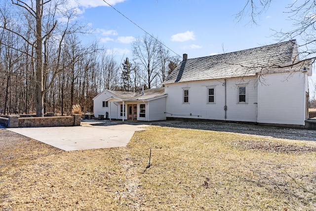 rear view of property featuring a patio area and a chimney