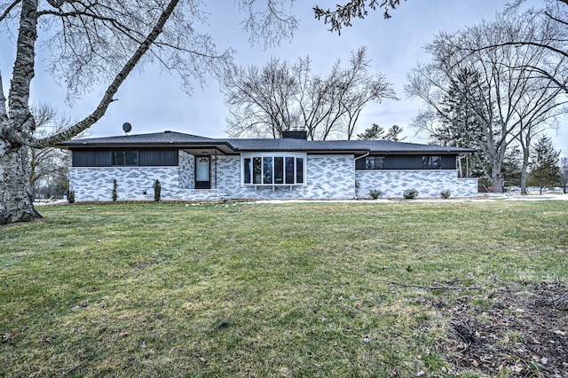 mid-century inspired home with brick siding, a chimney, and a front yard