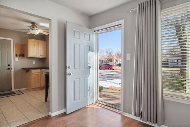 entrance foyer with ceiling fan, light tile patterned flooring, and baseboards