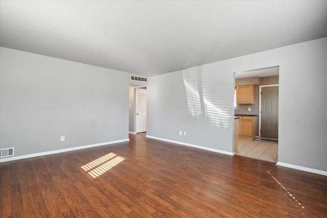 unfurnished room with light wood-type flooring, visible vents, and baseboards