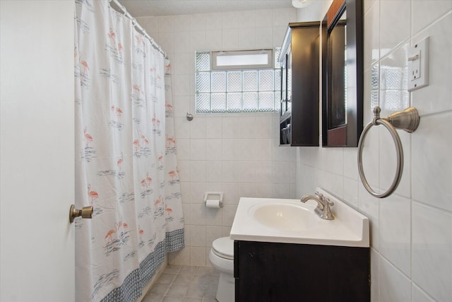 full bathroom with toilet, vanity, tile patterned flooring, and tile walls