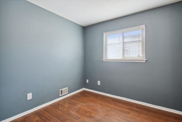 unfurnished room with visible vents, baseboards, and wood finished floors