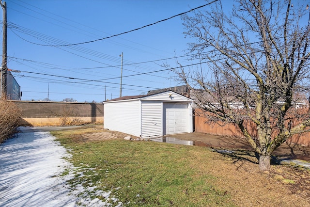 view of outdoor structure with driveway, fence, and an outdoor structure