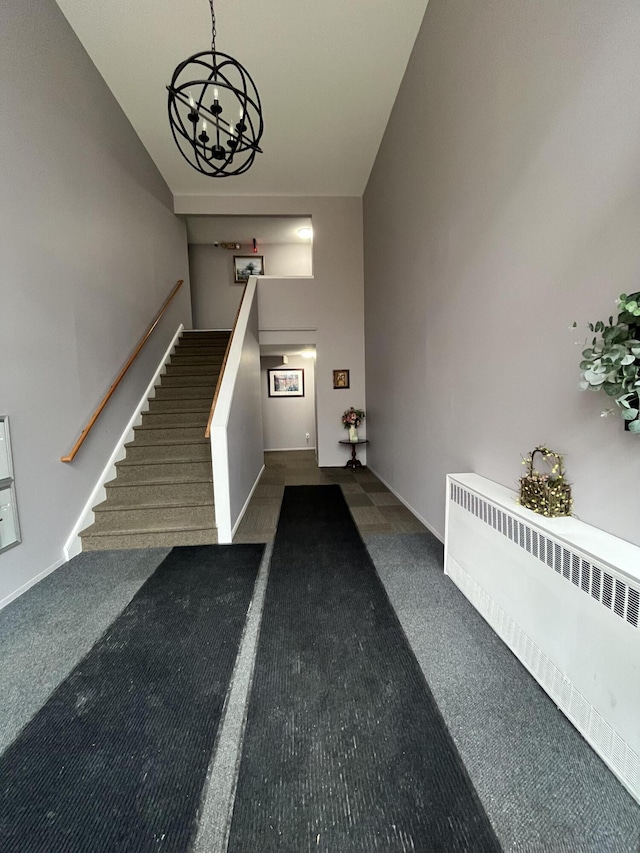 interior space with baseboards, radiator heating unit, carpet, and a notable chandelier