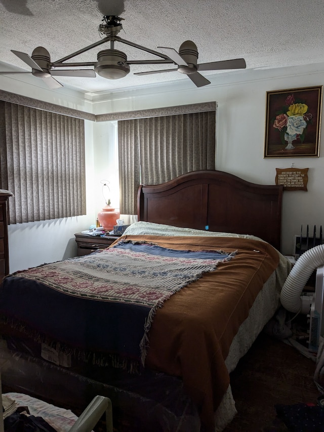 bedroom with a ceiling fan and a textured ceiling