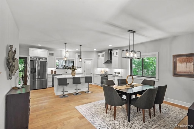 dining space with light wood-type flooring, baseboards, and recessed lighting