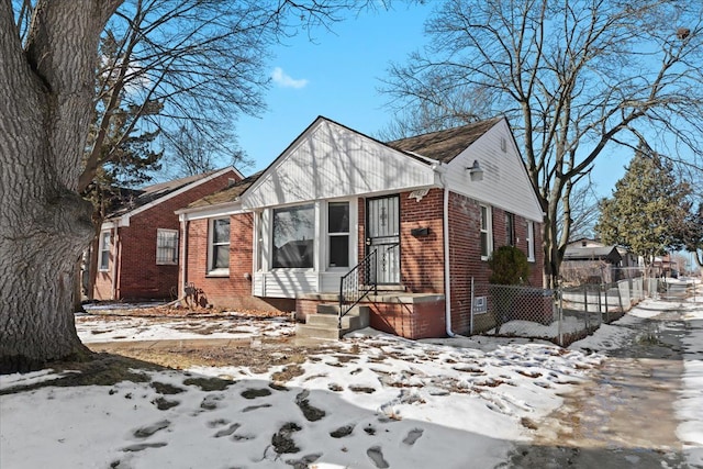 view of front of home with brick siding and fence