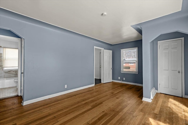 unfurnished bedroom with baseboards and wood finished floors