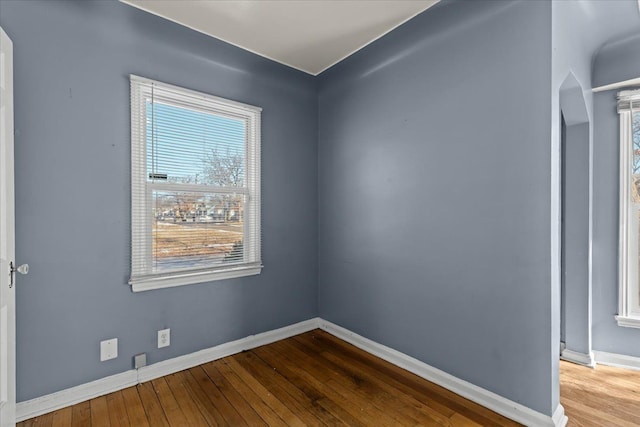 spare room with wood-type flooring and baseboards