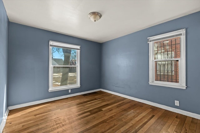 empty room featuring wood-type flooring and baseboards