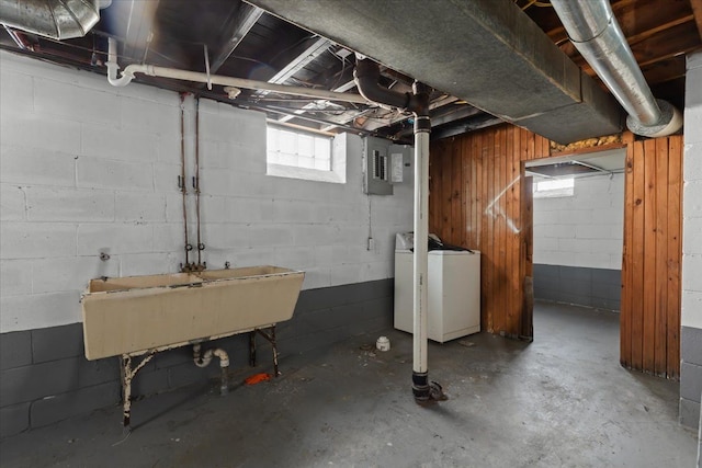 below grade area with washer / clothes dryer, a sink, and electric panel