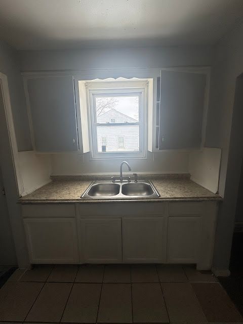 kitchen with a sink and dark tile patterned flooring