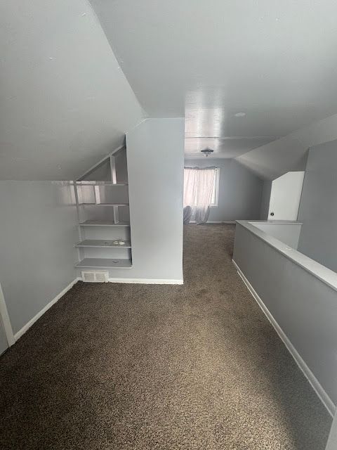 bonus room featuring carpet floors, baseboards, and lofted ceiling