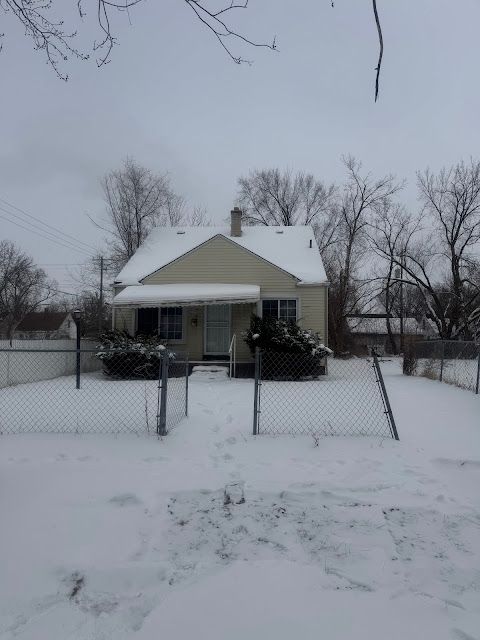 view of front of house with a chimney and fence