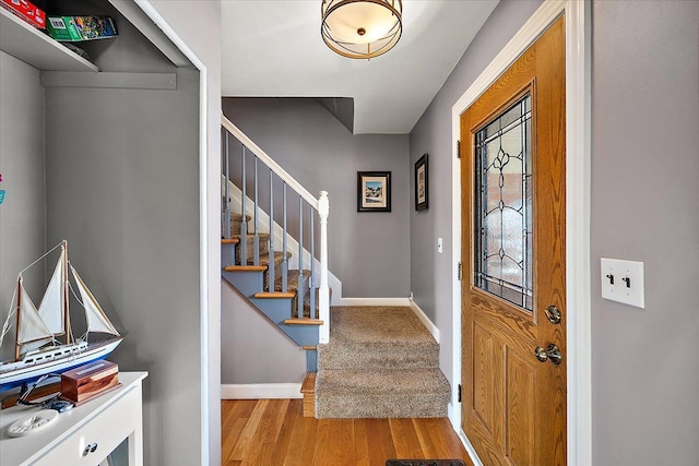 entryway featuring stairs, light wood-type flooring, and baseboards