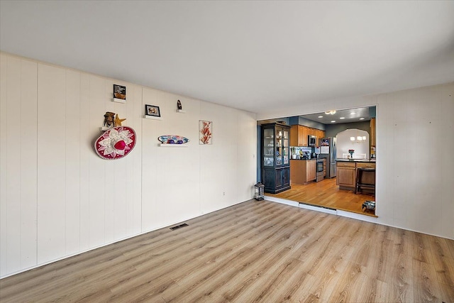 unfurnished living room featuring light wood-type flooring and visible vents