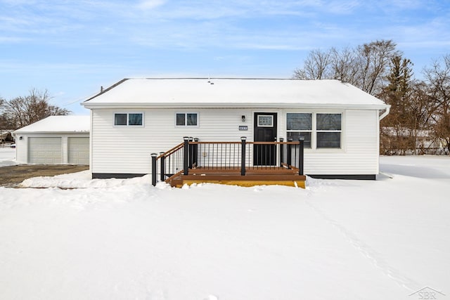 view of front of home with a garage and an outbuilding