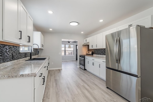 kitchen with appliances with stainless steel finishes, a sink, white cabinetry, and under cabinet range hood