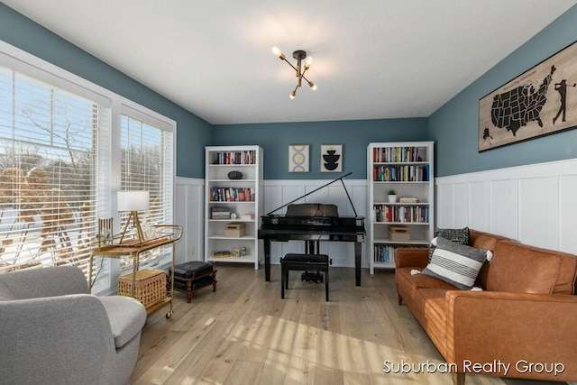 living area with a wainscoted wall and light wood-type flooring