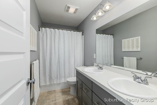 full bathroom featuring double vanity, visible vents, a sink, and shower / bath combo with shower curtain