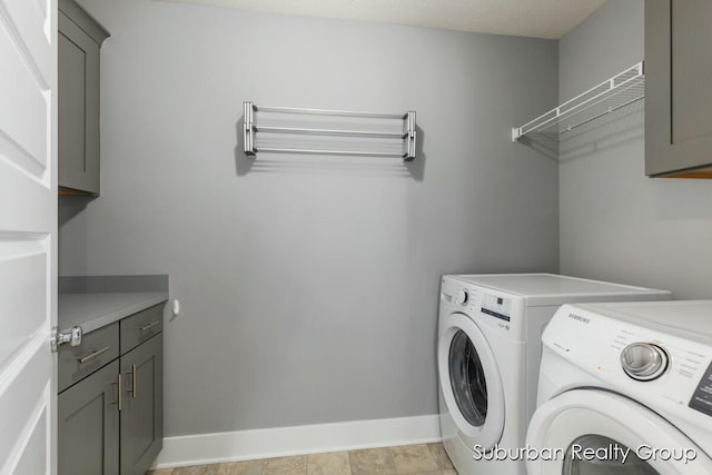 laundry area with cabinet space, baseboards, and washer and dryer