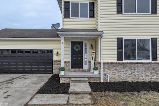 property entrance with driveway, brick siding, roof with shingles, and an attached garage