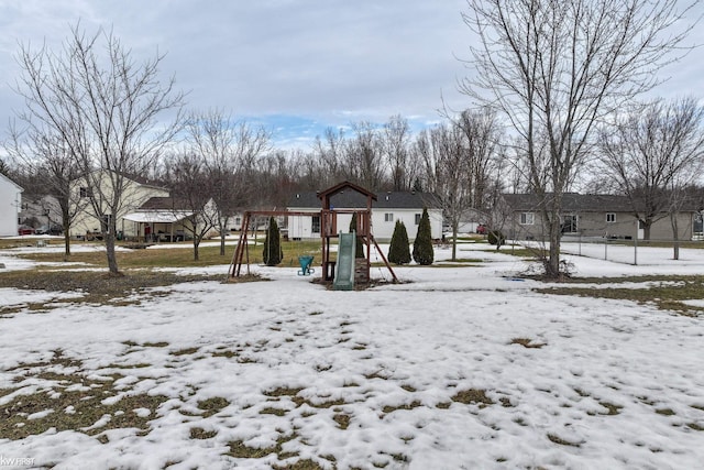 snow covered playground with a residential view