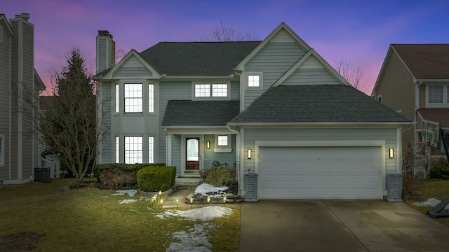 traditional-style house with an attached garage, driveway, a chimney, and roof with shingles