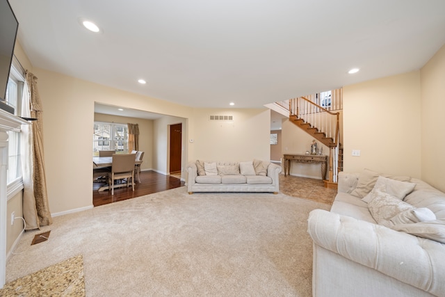 carpeted living room with visible vents, stairway, baseboards, and recessed lighting