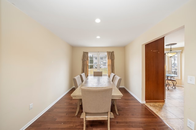 dining space with wood finished floors, a wealth of natural light, and baseboards