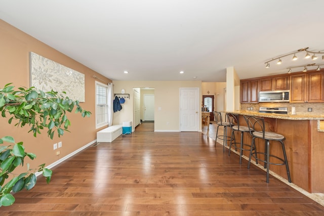 living area featuring recessed lighting, baseboards, and wood finished floors