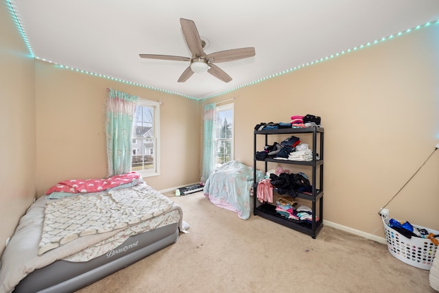 carpeted bedroom with ceiling fan and baseboards